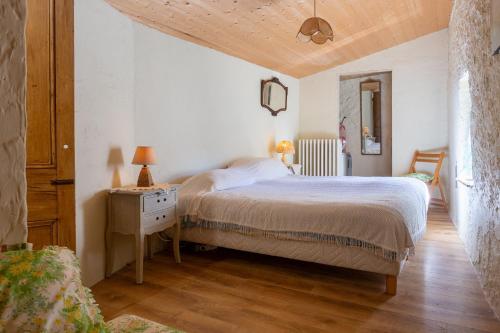 a bedroom with a bed and a wooden floor at Appartement 1 in Sauzet