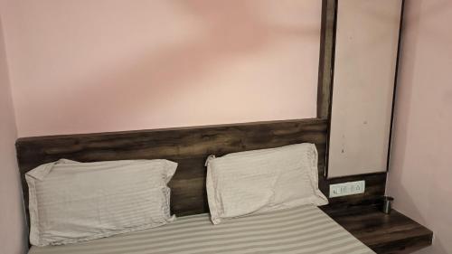 a bed with two pillows on top of it at Hotel M N Matheran in Matheran