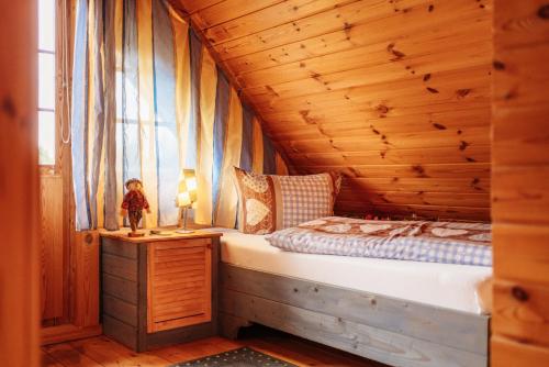 a bedroom with a bed in a wooden cabin at Der Fuchsbau - 3 Blockhäuser in Bad Sachsa