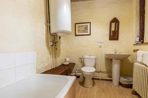 a bathroom with a tub and a toilet and a sink at Appartement 2 in Sauzet
