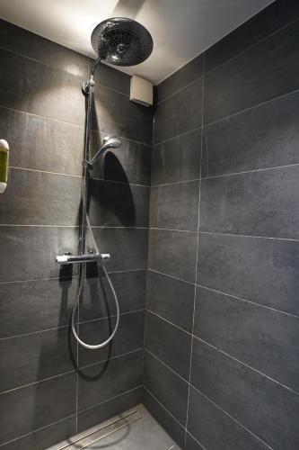 a shower with a shower head in a bathroom at Pension Dortmund Messe in Dortmund