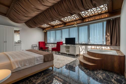 a bedroom with a bed and a tub and a tv at Ween Otel in Trabzon