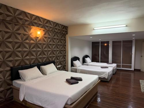 a hotel room with two beds and a mirror at The Bless Residence in Hat Yai