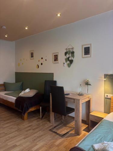 a room with a bed and a desk and a table at Apartmenthaus Wertheim in Wertheim