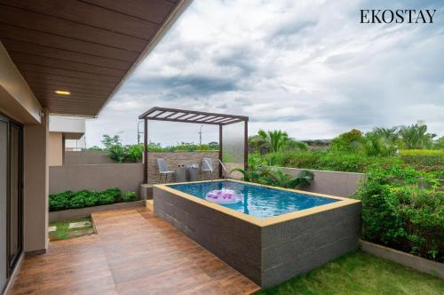a hot tub on the balcony of a house at EKOSTAY - Kara Villa in Karjat