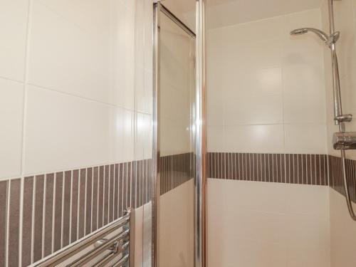 a shower with a glass door in a bathroom at Treveline in Bodmin