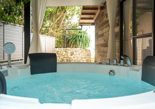 a jacuzzi tub with a table and chairs at simAsim Cottage Kouri in Nakijin