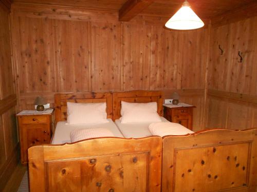 a bedroom with a bed in a wooden wall at Appartments Hofer in Stumm