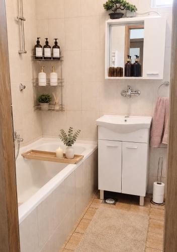 a bathroom with a tub and a sink and a bath tubermottermott at Apartman Ivano in Vukovar
