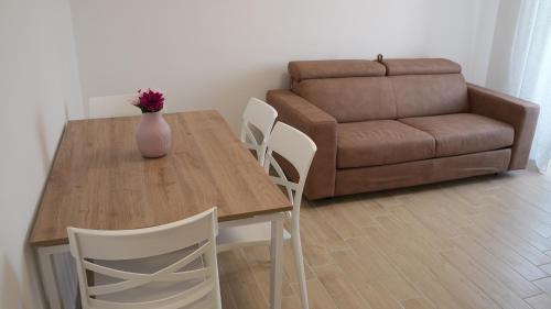 a dining room table and chairs with a vase on it at Sky Balcony - Milano Sud- vicino Humanitas e forum Assago in Rozzano