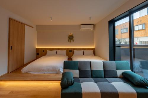 a bedroom with a bed and a couch and a window at Hotel Arina HakataTaihaku in Fukuoka