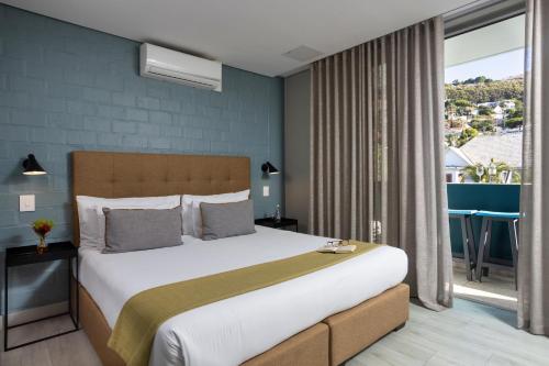 a bedroom with a large bed and a large window at Zest Boutique Hotel by The Living Journey Collection in Cape Town