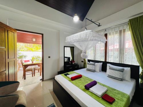 a bedroom with a large bed with red and white pillows at Ceylonima Home Stay in Anuradhapura