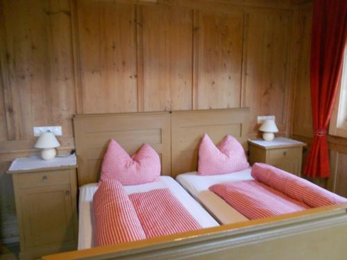 a bedroom with two beds with pink pillows at Appartments Hofer in Stumm