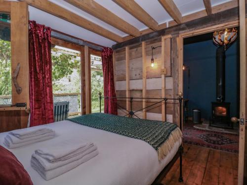 a bedroom with a bed in a room with a fireplace at Ferryman's Lodge in Chepstow