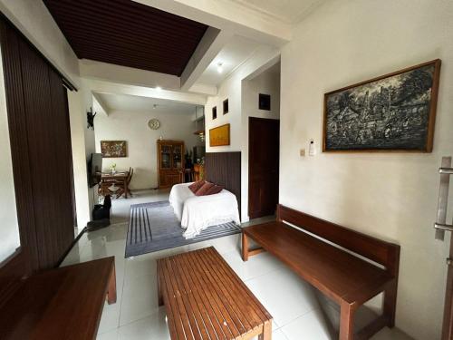 a bedroom with a bed and benches in a room at Villa Kecombrang in Salakan