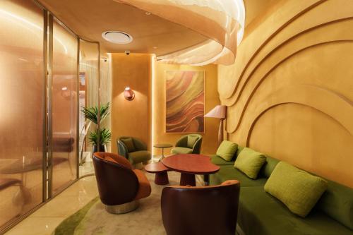 a living room with a green couch and a table at KiN Hotel Ly Tu Trong Edition in Ho Chi Minh City