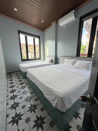 a bedroom with two beds and a tiled floor at Bông Phố Cổ Homestay in Ninh Binh