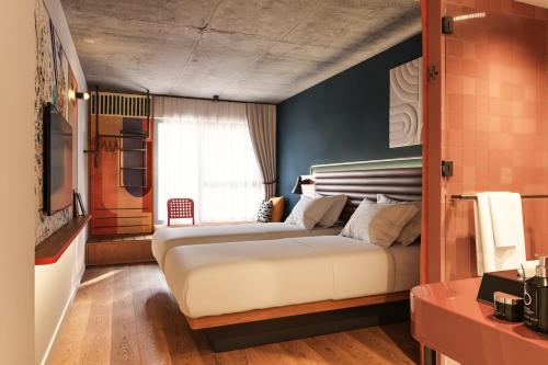 a bedroom with a large white bed in front of a window at Hotel Schani Naschmarkt - opening September 2026 in Vienna