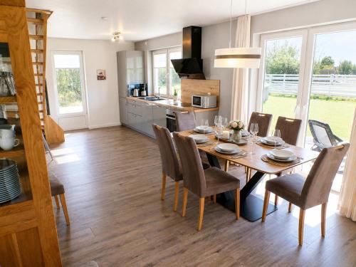 a dining room and kitchen with a table and chairs at Reetdachhaus 3, inkl 2 Parkplätze in Fehmarn