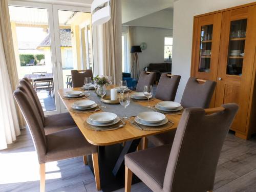 a wooden table with chairs and a dining room at Reetdachhaus 3, inkl 2 Parkplätze in Fehmarn