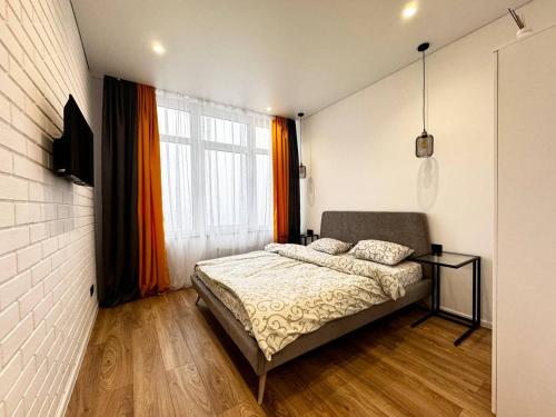 a bedroom with a bed and a large window at Kamanina Lux Apartment in Odesa