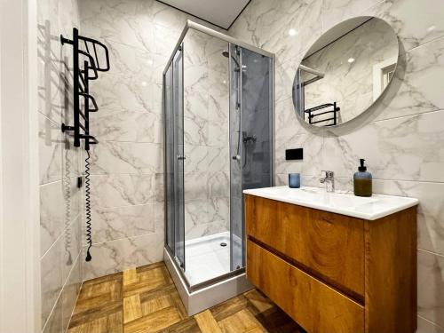 a bathroom with a shower and a sink and a mirror at Kamanina Lux Apartment in Odesa