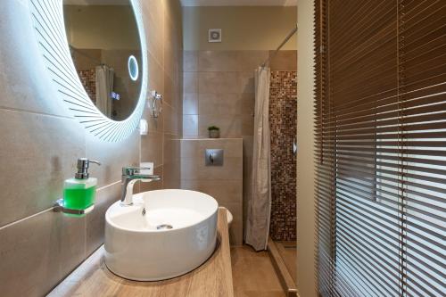 a bathroom with a white sink and a mirror at Beach Villa Christina by PosarelliVillas in Acharavi