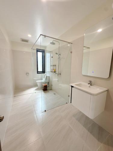a white bathroom with a sink and a mirror at SAM Homestay and Cafés in Thôn An Hòa