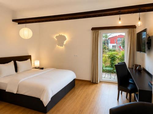 a bedroom with a bed and a desk and a window at S'Matt Bob in Feldkirch