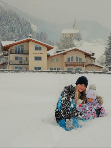 a woman and a child sitting in the snow at Green Apart in Uderns
