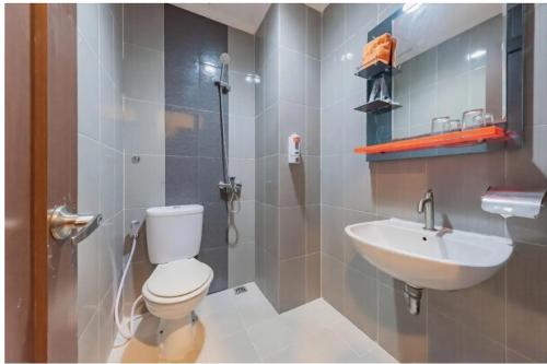 a bathroom with a toilet and a sink at Alqueby Hotel Bandung in Bandung