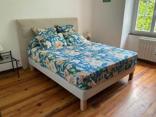 a bedroom with a bed with a blue floral comforter at Casa Defranchi in Sant Andrea di Bozio
