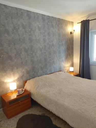 a bedroom with a bed and two lamps on tables at Vila Brig 108 - private swimming pool and jacuzzi in Rijeka