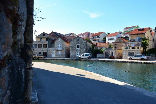 a body of water with cars parked next to houses at Apartments Ena in Vrboska