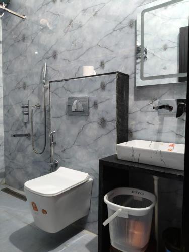 a bathroom with a toilet and a sink at Amrit hotel & resort in Nārāyanpur