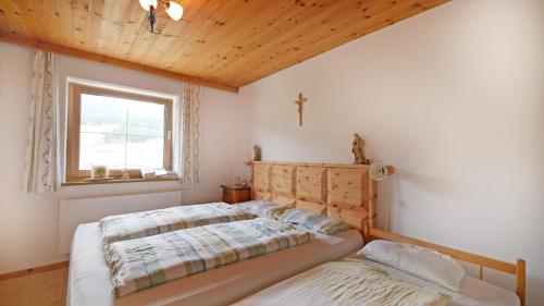 a bedroom with two beds and a window at Sonnseit in Sankt Johann in Tirol