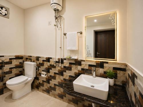 a bathroom with a toilet and a sink and a mirror at Shri Mangal Palace in Gwalior
