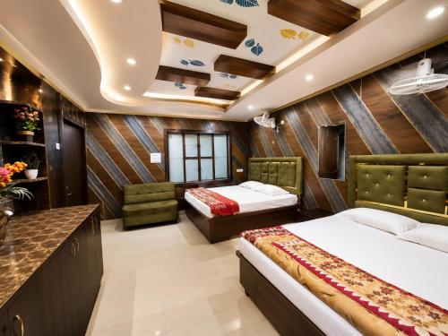 a hotel room with two beds and a counter at Shri Mangal Palace in Gwalior