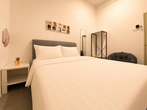 a bedroom with a large white bed and a chair at Casa Le Bliss (13) in Kuah