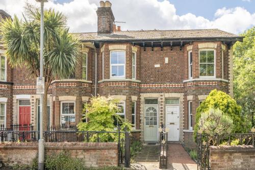 a brick house with a palm tree in front of it at Victorian Terrace near Uni sleeps 6 Garden in Reading