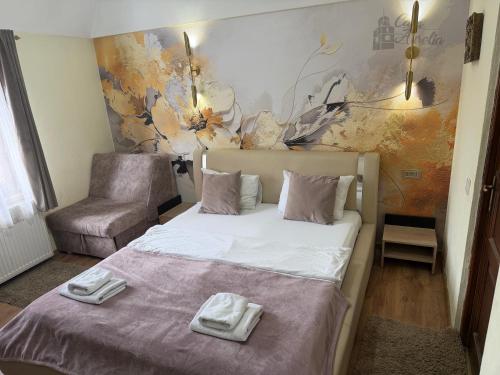 a bedroom with a bed with two towels on it at Casa Aurelia in Sibiu