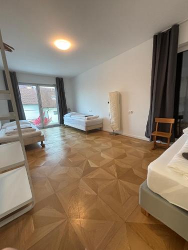 a room with two beds and a wooden floor at Haus mit Garten bei Wien in Langenzersdorf
