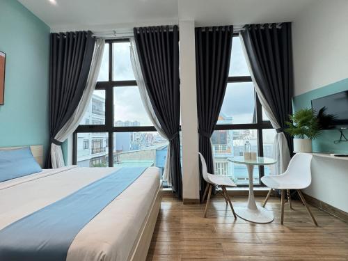 a bedroom with a large bed and a table and chairs at Ngôi Nhà Mơ Ước in Ho Chi Minh City