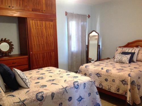 a bedroom with two beds and a mirror at Casa de la Tortuga in Zihuatanejo