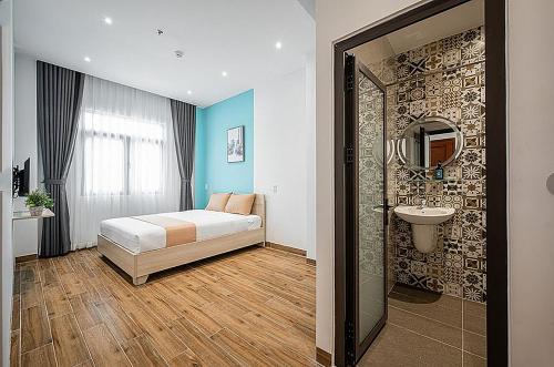 a bedroom with a bed and a sink and a mirror at Ngôi Nhà Mơ Ước in Ho Chi Minh City