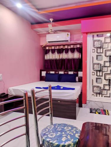 a room with a bed and two chairs in it at Hotel Happy House in kolkata