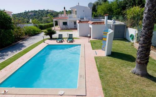a swimming pool in the backyard of a house at Villa Oliandra in Vilamoura