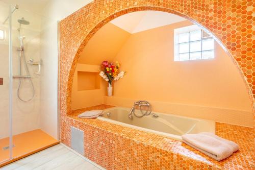 a bathroom with a bath tub and a shower at Chez Coco in Trégunc