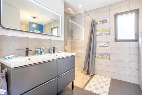 a bathroom with a sink and a shower at Sitelles Lodge Cube avec spa in Concarneau